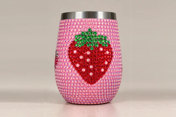 Pink rhinestone-covered wine tumbler with strawberry decoration